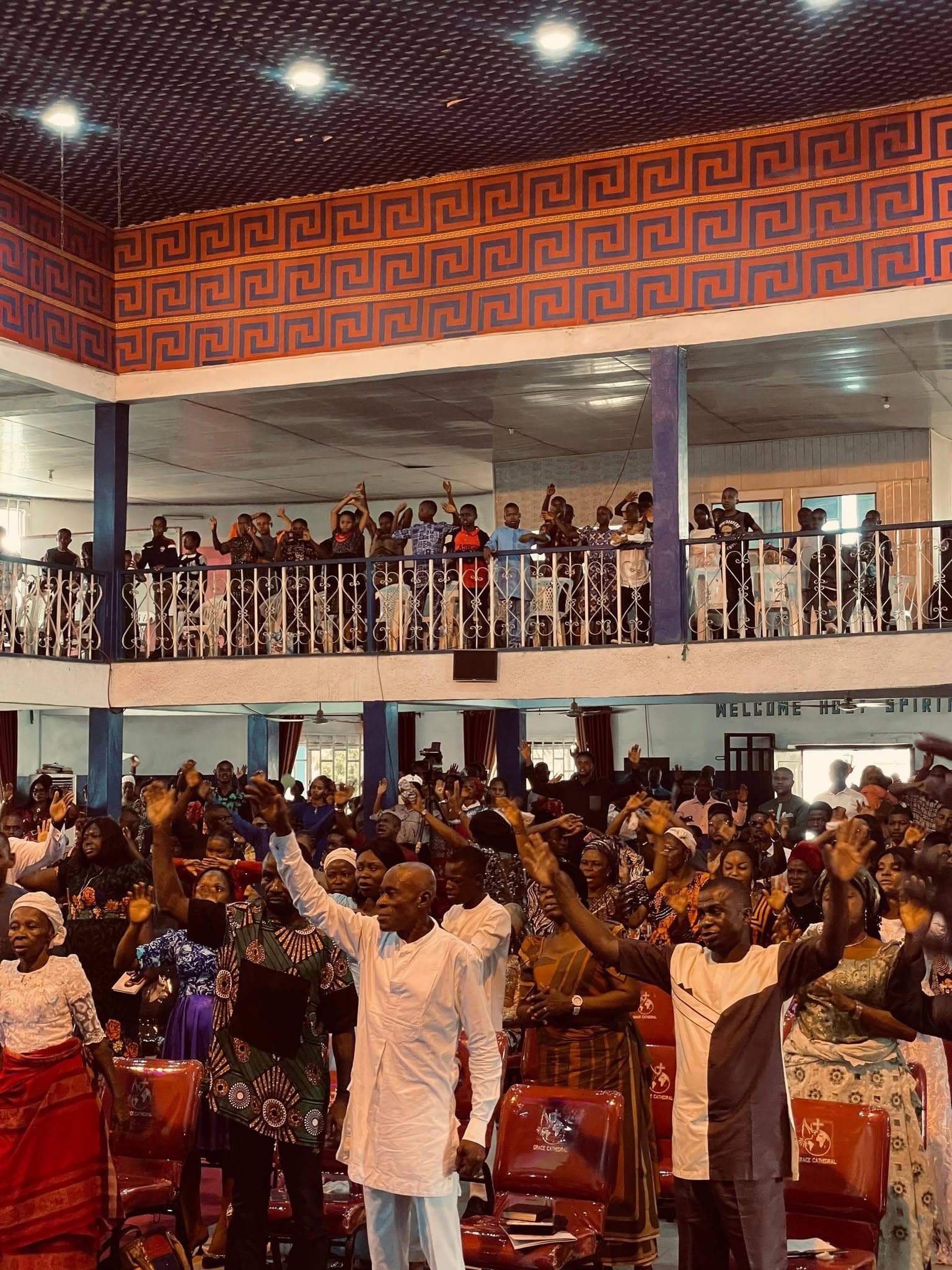 The congregation worshipping with hands raised at the anniversary